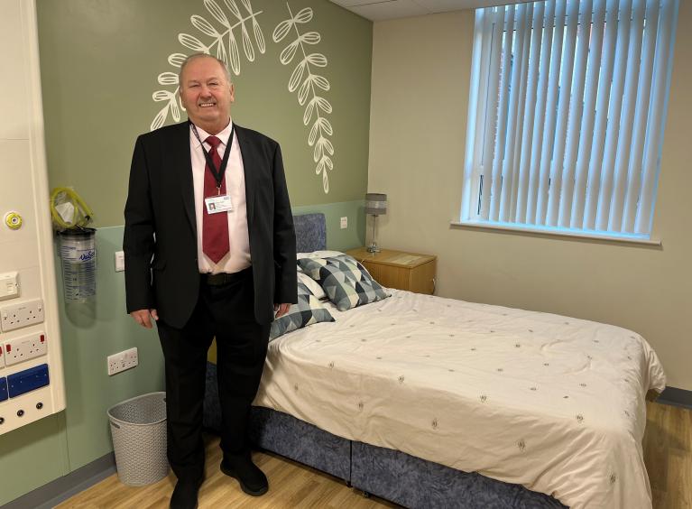 A person in a suit in one of the parent bedrooms on the neonatal unit