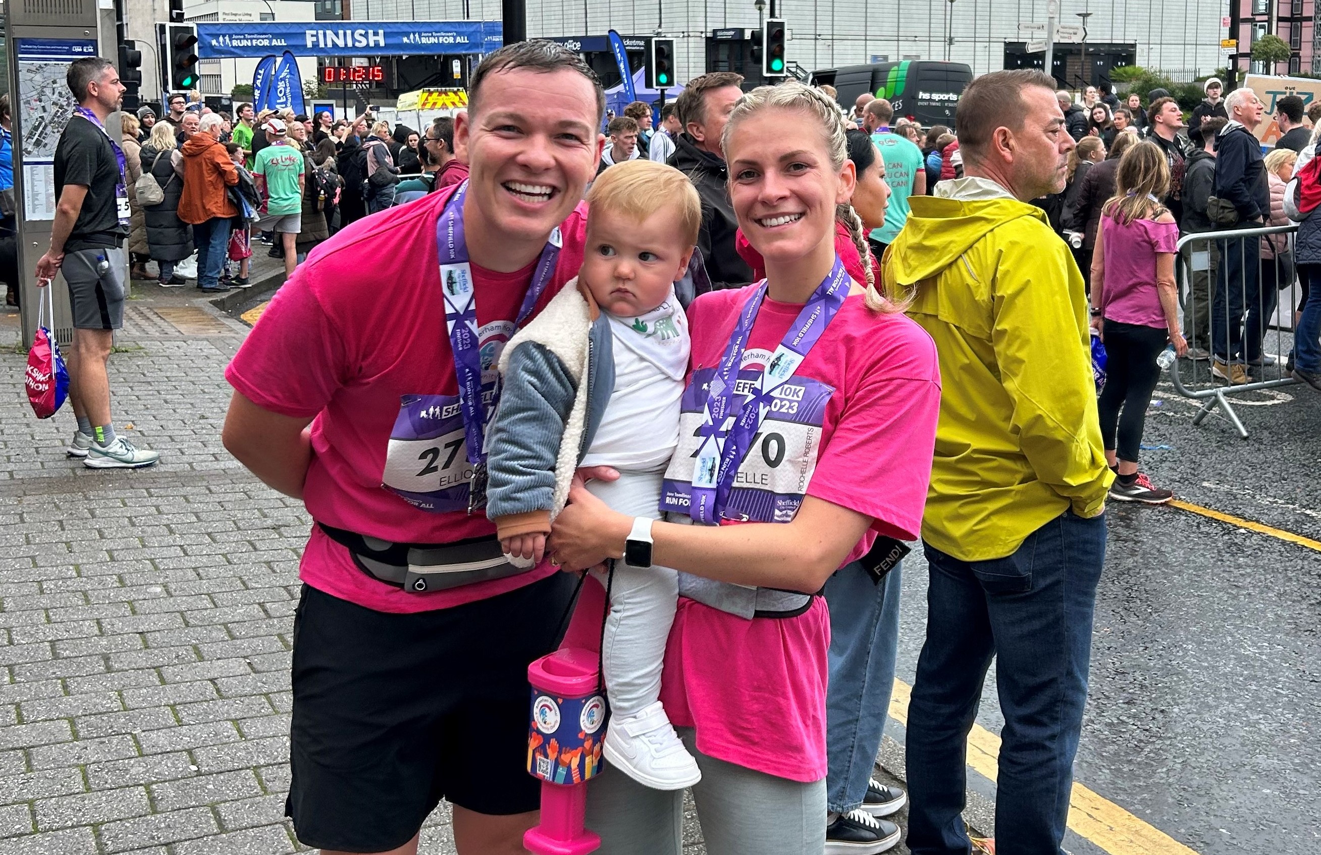 Richard, Ezrah, and Rochelle wearing their charity pink t-shirts and their medals