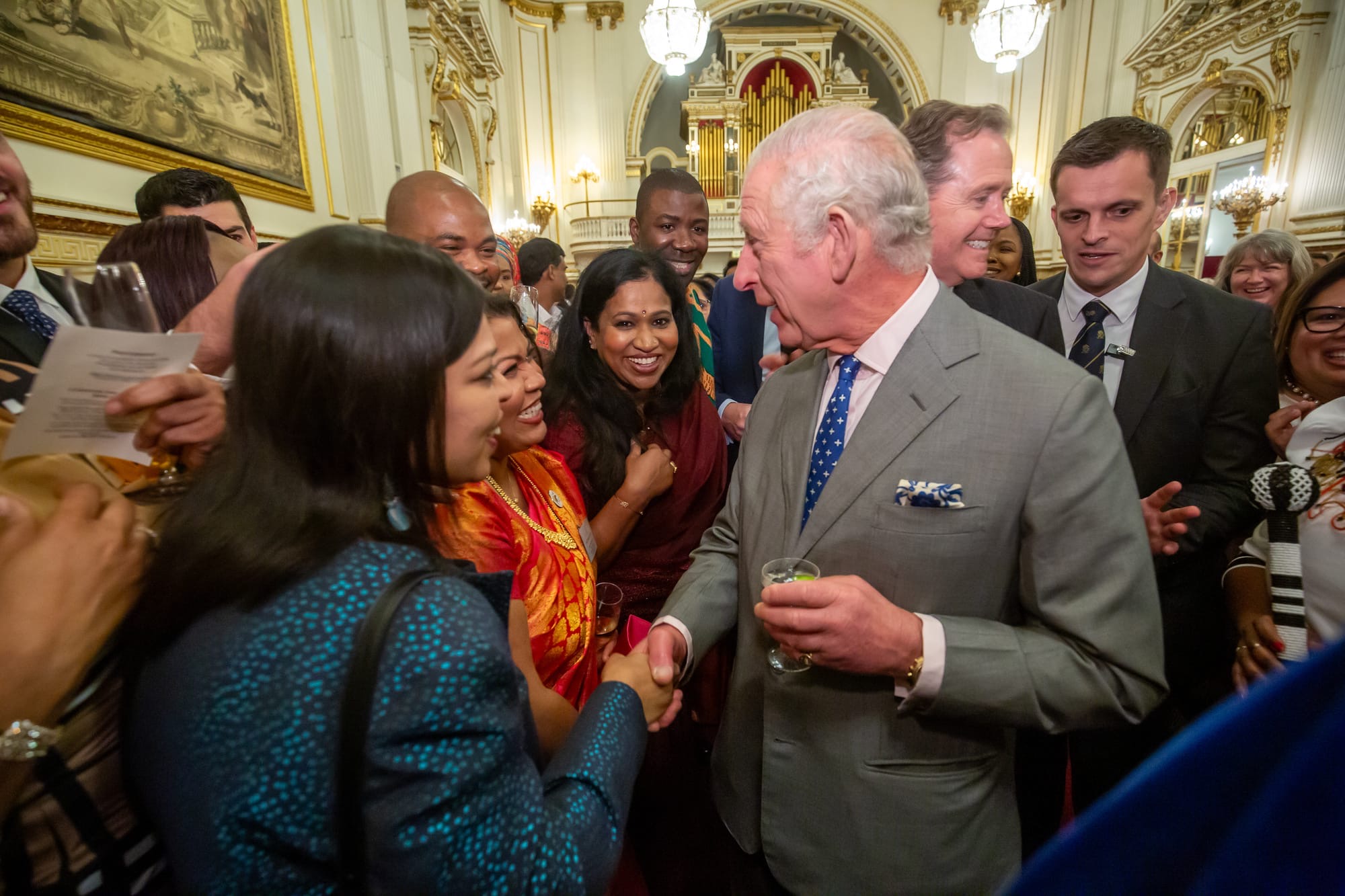 Swapna shaking hands with the King surrounded by other excited visitors to the Palace