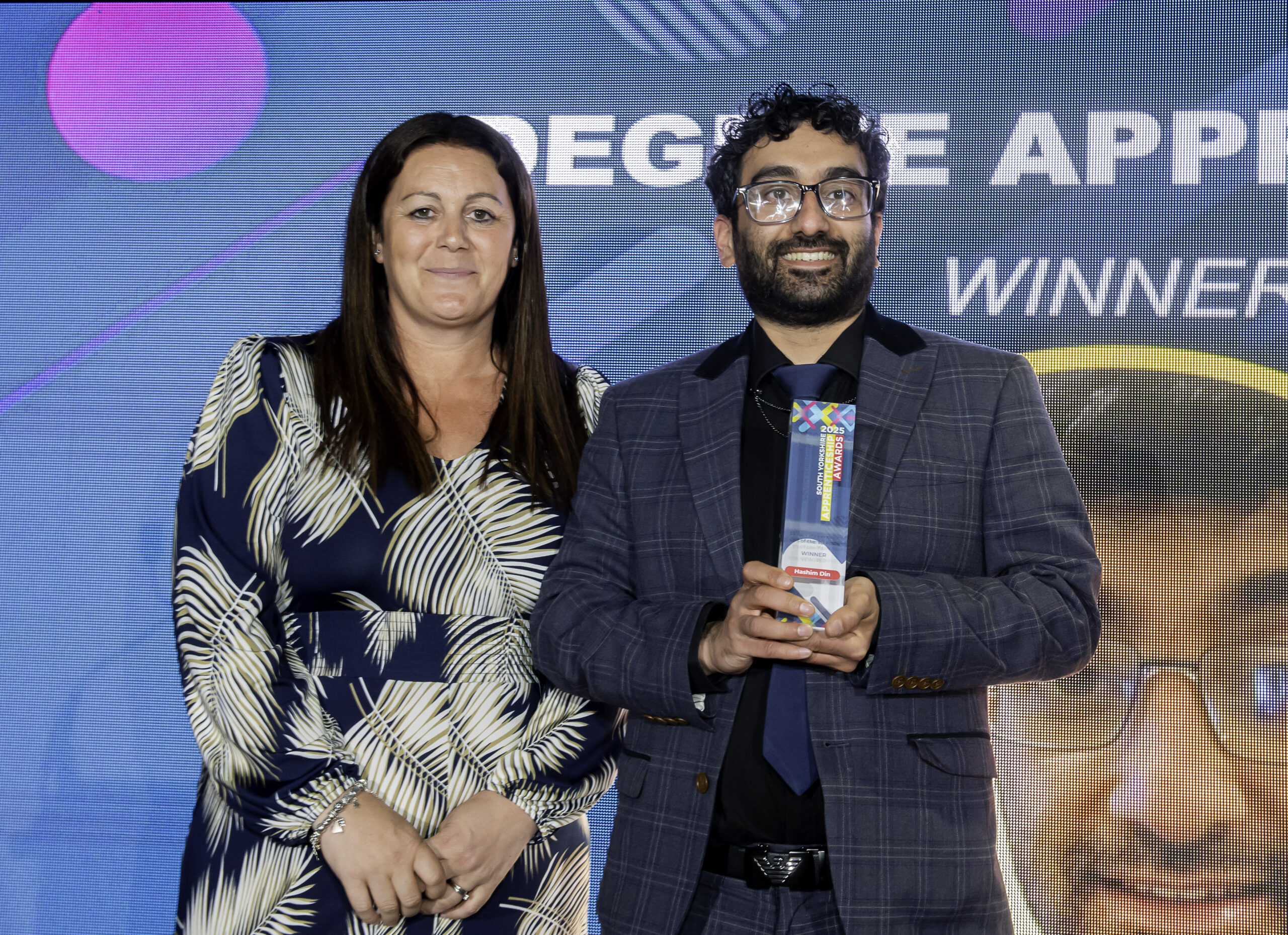 Hashim Din is presented with a glass trophy