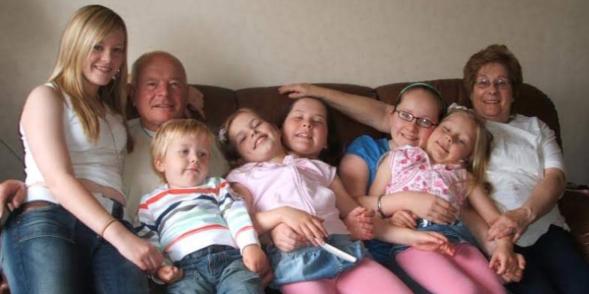 Sadie posing on a family photo with her siblings, cousins and Grandparents