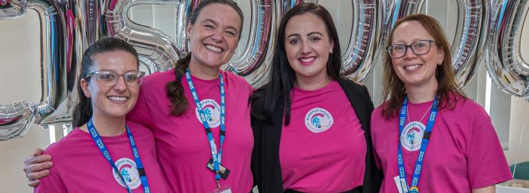 The Rotherham Hospital and Community Charity team smiling in pink branded t-shirts