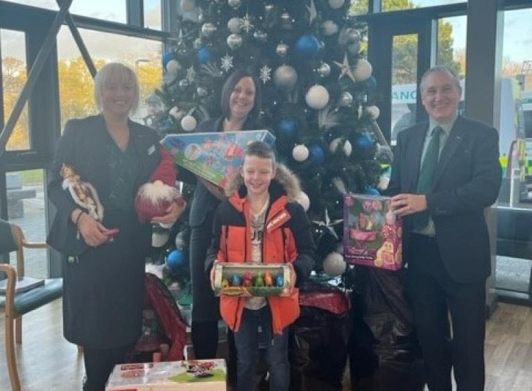 Lloyds staff pictured with donated children's toys in front of a Christmas tree