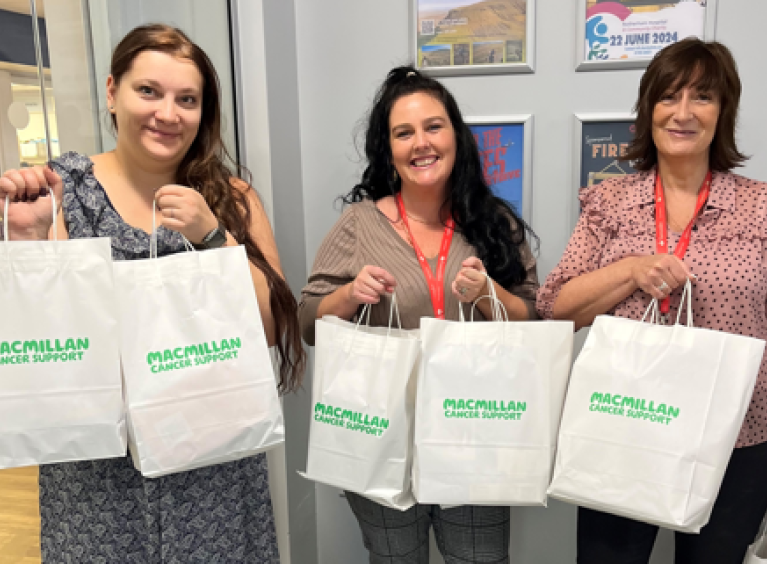 Three Santander colleagues holding bags of donations