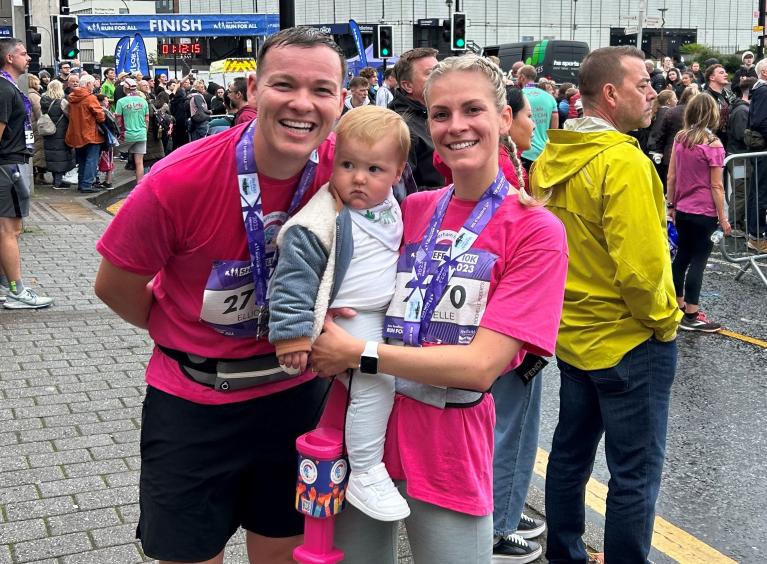 Richard, Ezrah, and Rochelle wearing their charity pink t-shirts and their medals