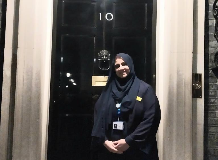 Maysoon is stood outside the door of 10 Downing Street wearing a black hijab and salwar kameez