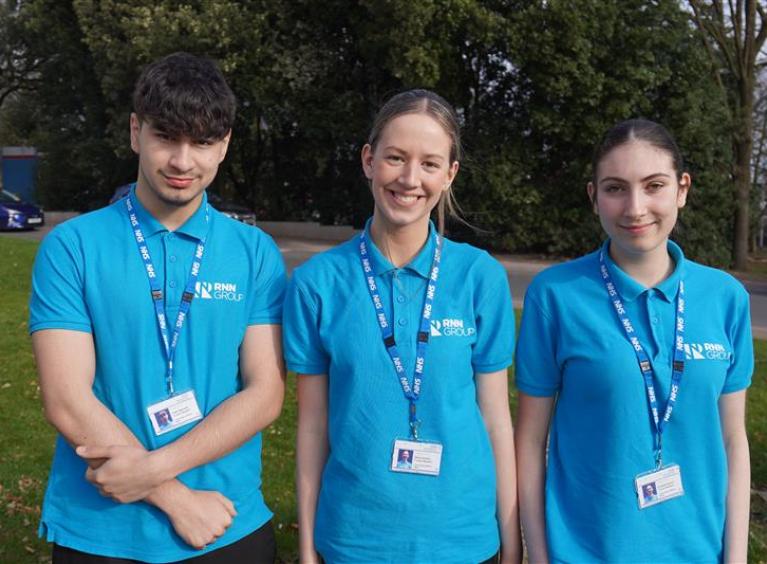Three T-Level students in blue polo shirts.