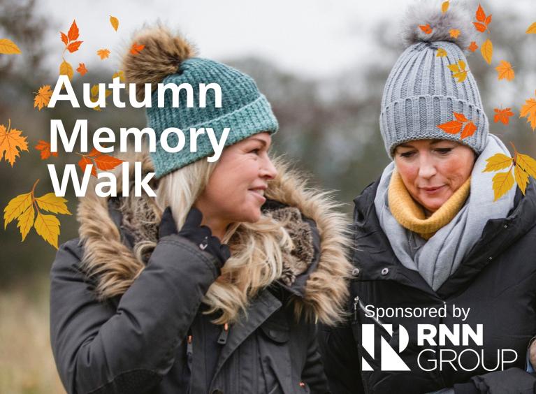 Two ladies walking together wearing winter coats and hats with the words 'Autumn Memory Walk' Sponsored by RNN Group.