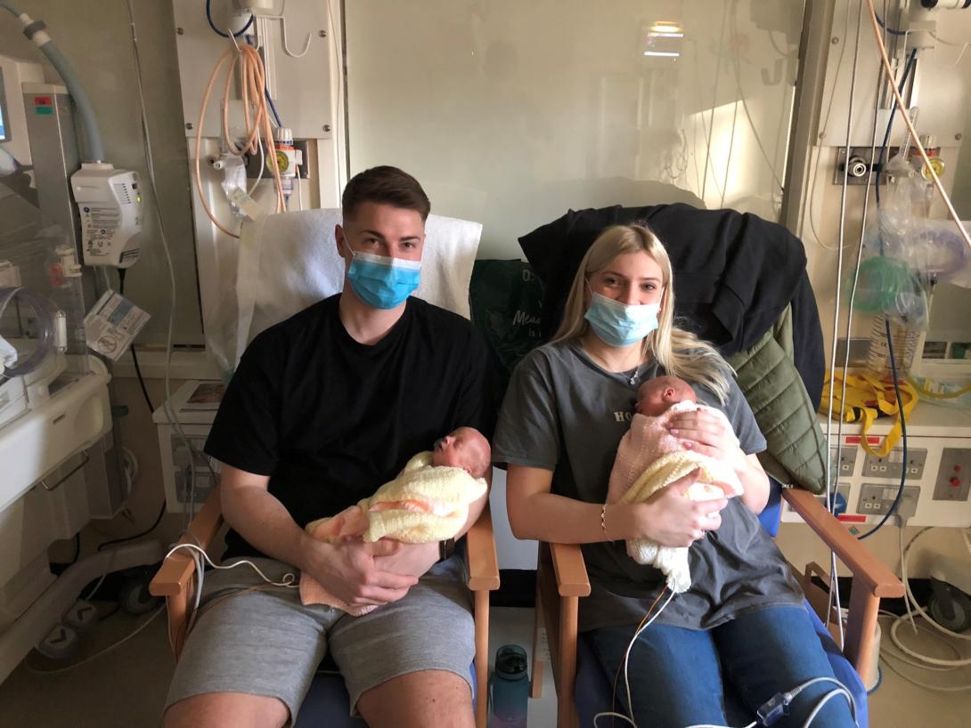 Two small babies with their parents on the special care baby unit.