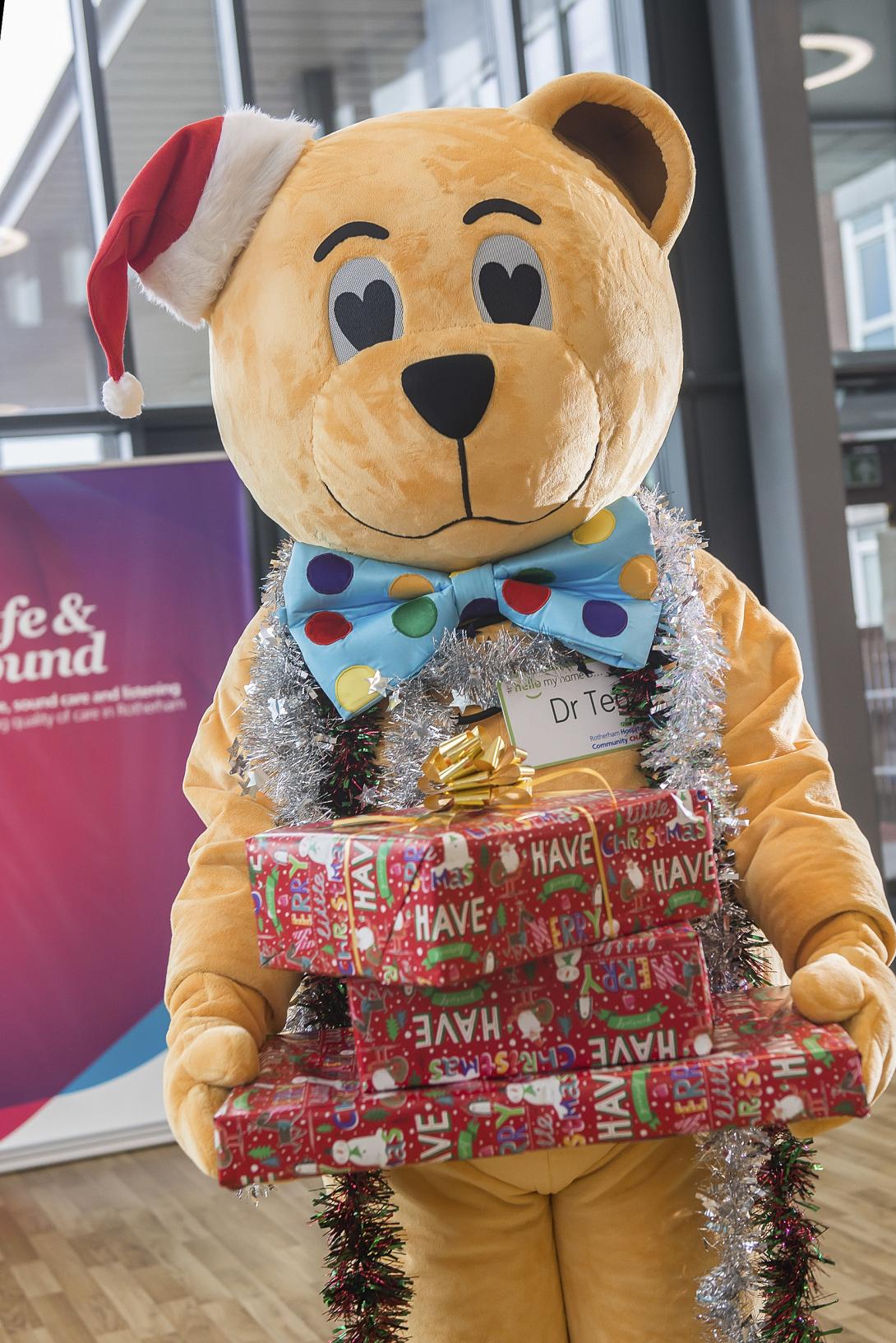 Dr Ted wearing a Santa hat and holding Christmas presents