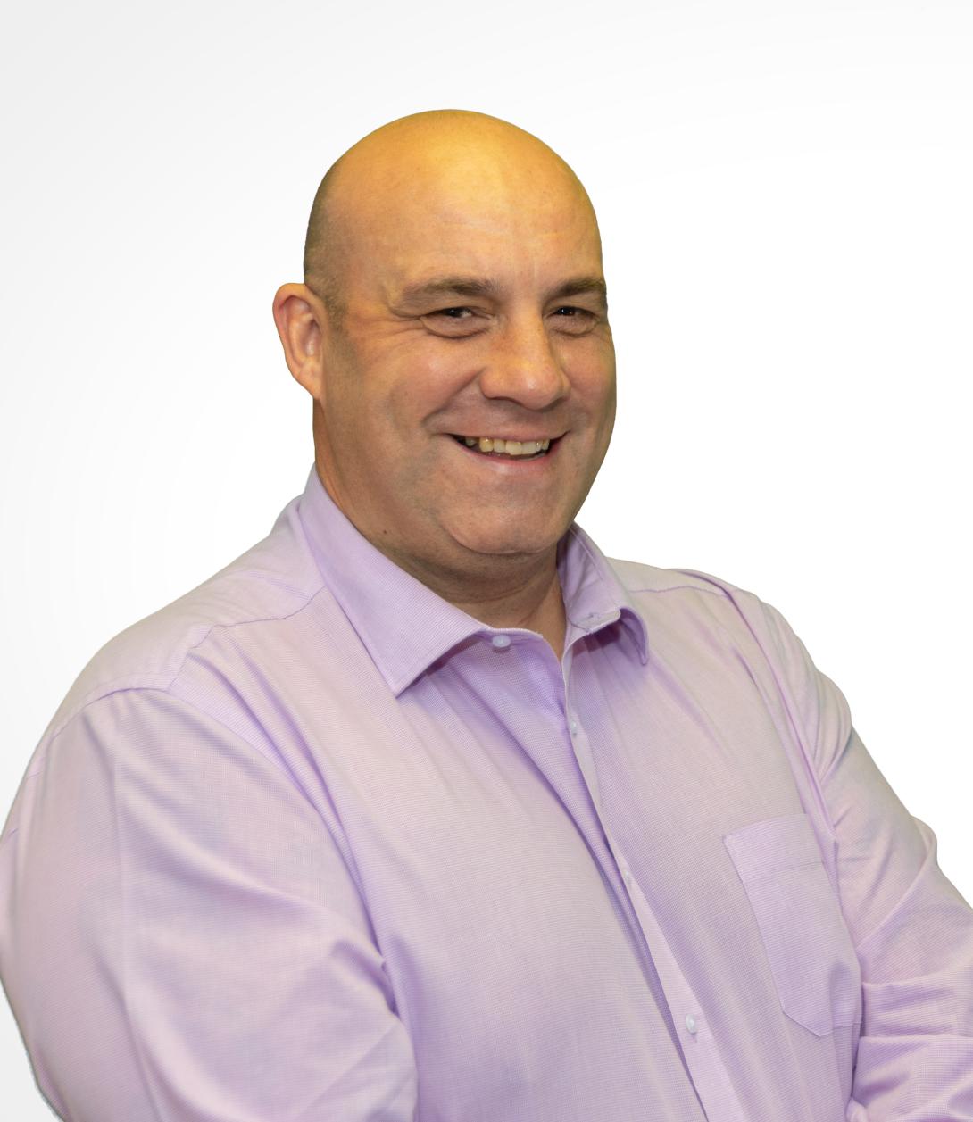 Matt Skelding wearing a light pink shirt against a white background