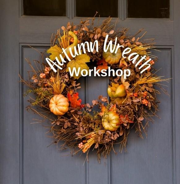 An autumn wreath hung on a door with the words Autumn Wreath Workshop