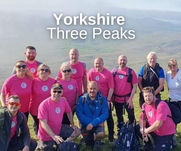 A team of walkers posing at the top of a mountain. With the words Yorkshire Three Peaks.